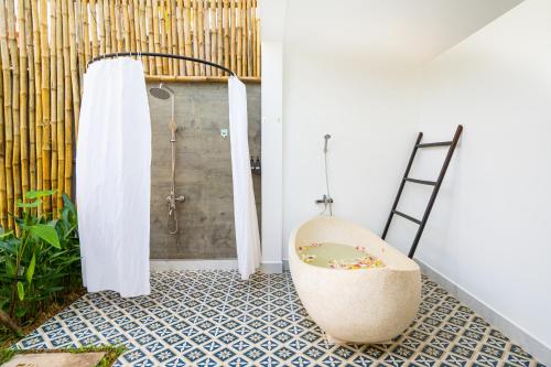 uma casa de banho com uma cadeira e um chuveiro em Angkor Tempora Boutique em Siem Reap