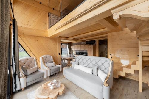 Una sala de estar con un sofá y sillas y una mesa. en Chaletovo Mountain Residences, en Zakopane