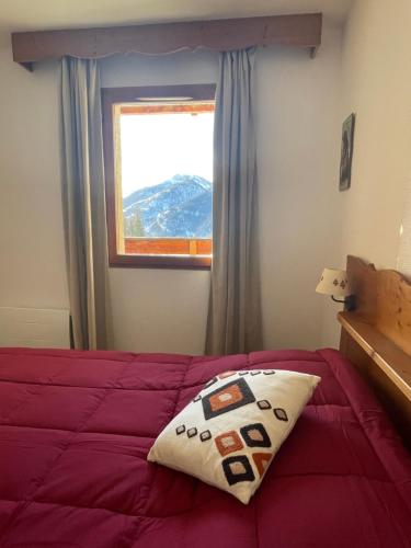 1 dormitorio con cama con almohada en AU PIED DES PISTES D'ARVIEUX en Arvieux