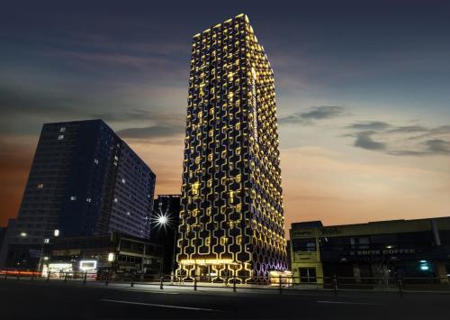 a tall building with lights on the side of it at Hotel The Designers Premier Kondae in Seoul
