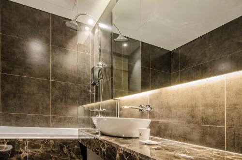 uma casa de banho com um lavatório e uma banheira em Hotel The Designers Premier Kondae em Seul