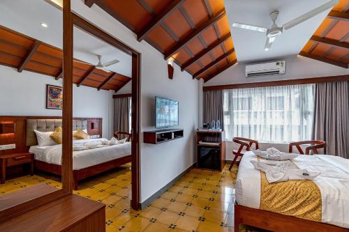 een slaapkamer met 2 bedden en een spiegel bij Palcastle Regency in Palakkad