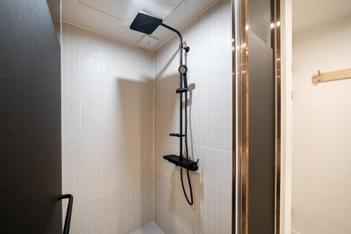 a shower with a shower head in a bathroom at Baron De Hotel in Seoul