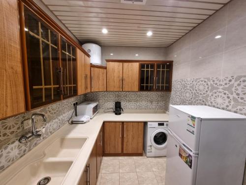 a kitchen with a sink and a washer and dryer at شقق نبراس الفارس للشقق المخدومة - اقتصادي in Tabuk