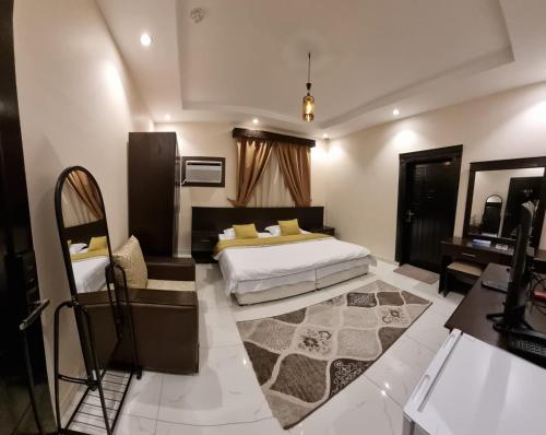 a bedroom with a bed and a desk and a table at شقق نبراس الفارس للشقق المخدومة - اقتصادي in Tabuk