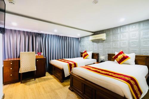 a hotel room with two beds and a desk at King Hotel Saigon Airport in Ho Chi Minh City