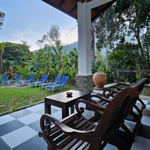 a group of chairs and a table on a patio at Ella Planters Bungalow in Ella