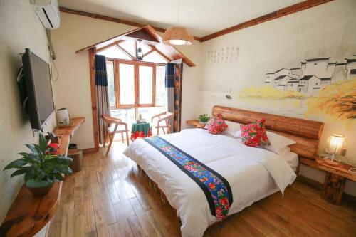 a bedroom with a large bed and a large window at Time Away Inn in Zhangjiajie