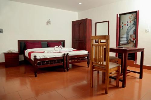 KTM PRINCEINN في كالباتّا: غرفة نوم بسرير وطاولة وكرسي