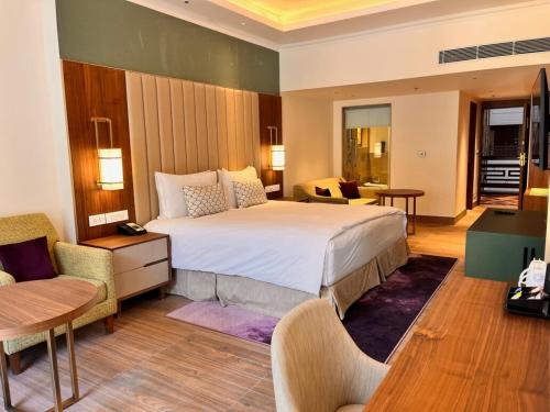 a hotel room with a large bed and a living room at Vivanta Tawang in Tawang