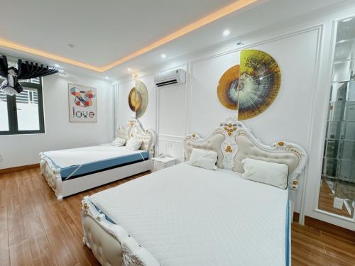 a white bedroom with two beds and a window at Sky Star 2 Hotel in Can Tho