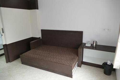 uma cama num quarto ao lado de uma parede em Prakash home stay em Ooty