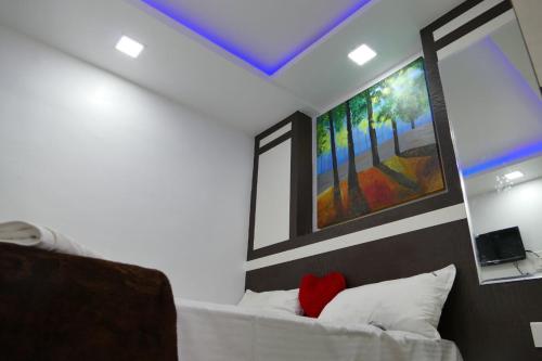 um quarto com uma cama com um quadro na parede em Prakash home stay em Ooty