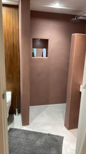 La salle de bains est pourvue de toilettes et d'un mur marron. dans l'établissement Montys Accommodation, à Lewes
