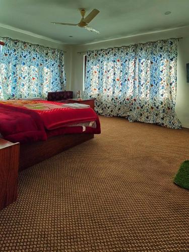 a bedroom with a large bed with blue curtains at Tip Top Pahalgam in Pahalgām