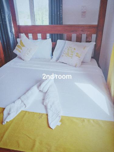 a bed with white sheets and pillows on it at Bree Airbnb in Malindi