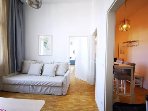 ein Wohnzimmer mit einem weißen Sofa und einem Tisch in der Unterkunft SC 7 Cozy Family & Business in Berlin