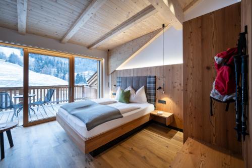 a bedroom with a bed and a large window at Proderhof in Laion