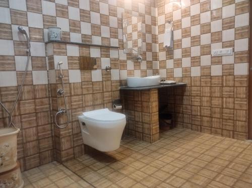 een badkamer met een toilet, een douche en een wastafel bij Great Tiger Resort in Belparāo