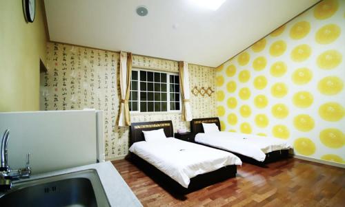 a kitchen with two beds in a room with a sink at Jeju Arbon Resort in Jeju