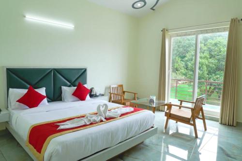 Un dormitorio con una cama grande y una ventana en Great Tiger Resort, en Belparāo