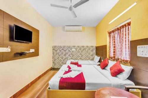 a hotel room with two beds and a flat screen tv at Season 4 Residences -Thiruvanmiyur Near Tidel park Apollo Proton cancer center and IIT Madras Research Park in Chennai
