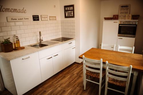 a kitchen with white cabinets and a wooden table at Villa Knoche in Arnsberg
