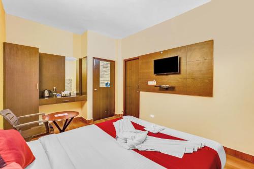 a hotel room with a bed and a tv at Season 4 Residences -Thiruvanmiyur Near Tidel park Apollo Proton cancer center and IIT Madras Research Park in Chennai