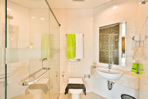 a white bathroom with a sink and a shower at Maxone Premier Melawai in Jakarta