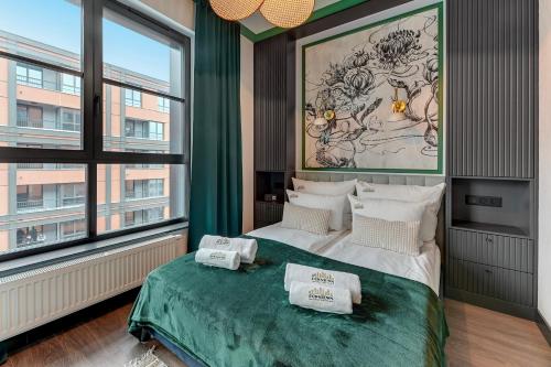 um quarto com uma cama e uma grande janela em Downtown Apartments DOKI Living - Foodhall & Parking em Gdansk