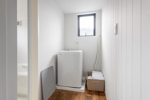 a bathroom with a white refrigerator and a window at 船堀戸建 in Tokyo