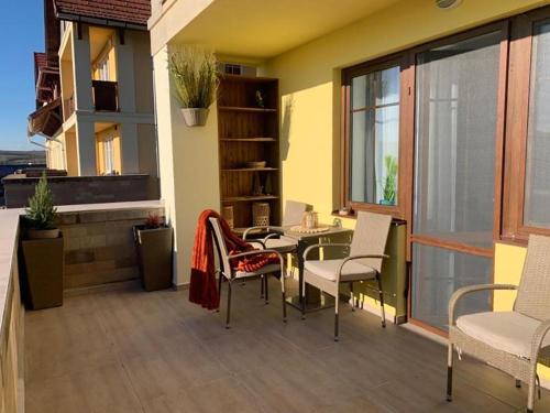 a patio with a table and chairs on a balcony at Sóvirág Apartman in Egerszalók