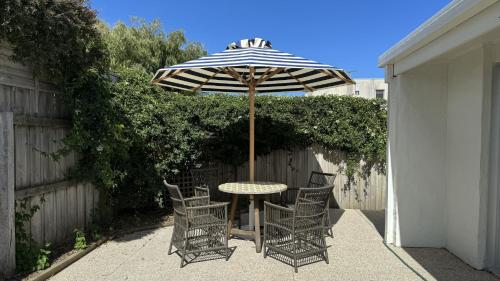 a table and chairs under an umbrella on a patio at Torquay Hotel/Motel in Torquay