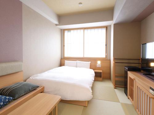 a small room with a bed and a television at Onyado Nono Asakusa Bettei Hot Spring in Tokyo