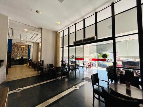 een restaurant met tafels en stoelen en een groot raam bij Flat aconchegante in Goiânia