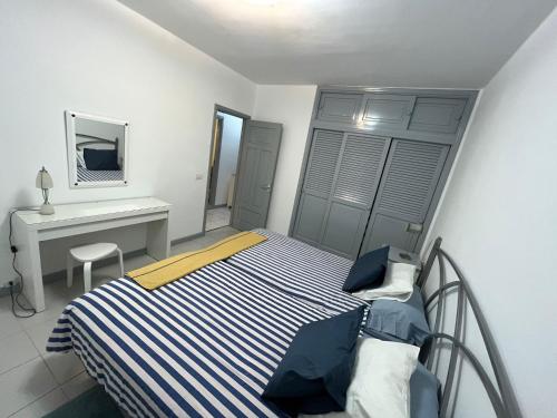 1 dormitorio con cama y escritorio. en Casa marea, en Puerto Calero