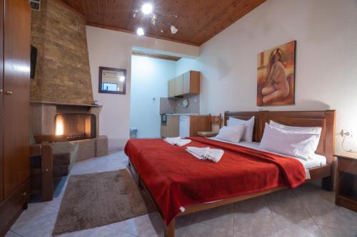 1 dormitorio con 1 cama grande y chimenea en Guesthouse Adonis, en Kato Loutraki