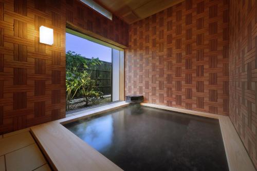 a swimming pool in a room with a large window at 天童荘 TENDOSO in Tendo