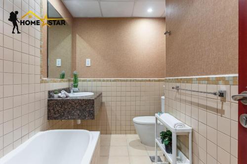 a bathroom with a tub and a toilet and a sink at HOMESTAR, Jumeirah Beach Hostel - JBR - Pool, Beach, Metro in Dubai