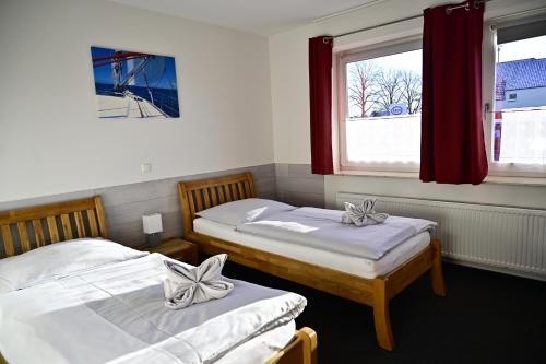 two beds in a room with two windows at Pension Allerdomizil in Celle