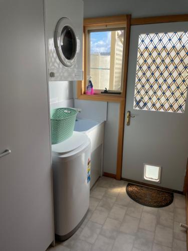 y baño con lavabo y lavadora. en ‘Rose Cottage’ sisters beach accommodation, en Sisters Beach