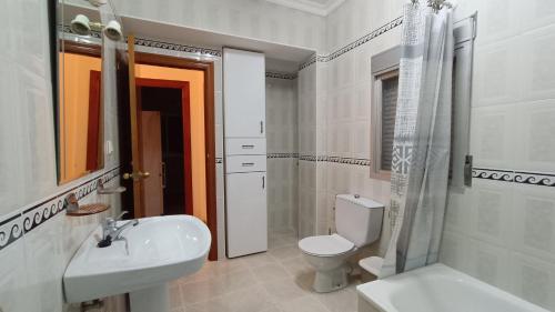 ein weißes Bad mit einem WC und einem Waschbecken in der Unterkunft APARTMENT WITH SINGLE ROOMS in Algodonales