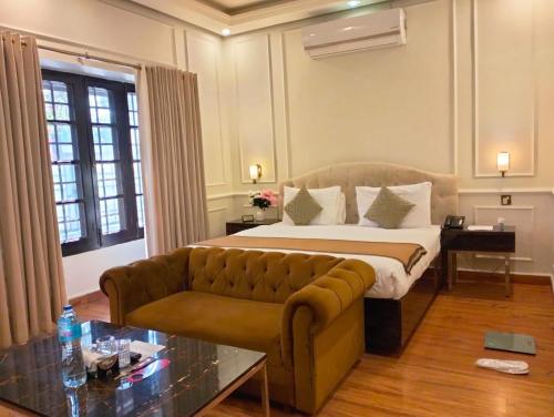 a hotel room with a bed and a couch at Riviera Courtyard Guest House Islamabad in Islamabad
