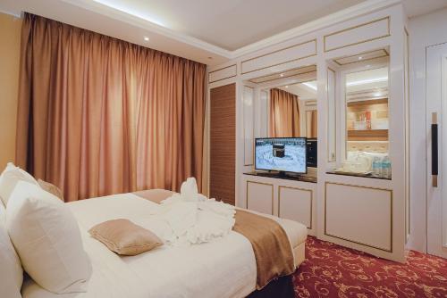 a hotel room with a bed and a television at Portola Grand Arabia Hotel in Banda Aceh