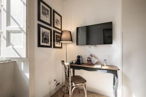 a desk with a television on a wall with a chair at The Bluehostel in Rome