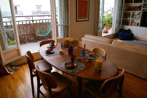een eetkamer met een tafel en stoelen en een bank bij Champerret in Parijs