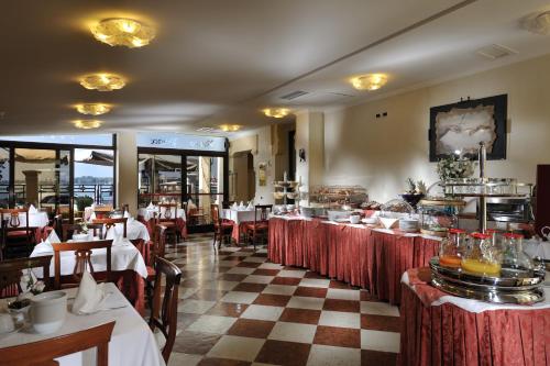 un ristorante con tavoli e sedie e un buffet di Hotel Russo Palace a Lido di Venezia