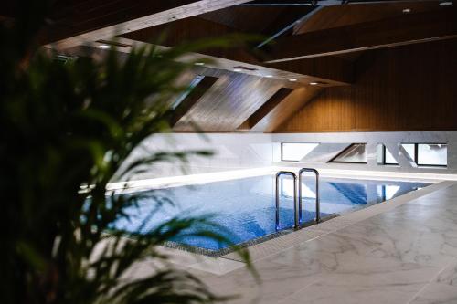 a swimming pool in a building with a ceiling at Podina Resort Hotel & Spa in Ungureni