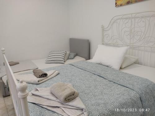 a bedroom with a white bed with towels on it at Budget Studio by the Sea in Perea