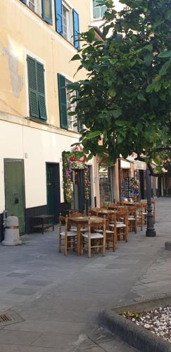 a row of wooden tables and benches next to a building at Acquamarina in Rapallo